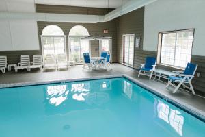 圣伊尼亚斯布雷克湖滨度假酒店的一个带蓝色椅子和桌子的游泳池