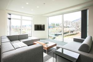 白马村Bluebird Apartments by The Hakuba Collection的客厅设有两张沙发和一个大窗户