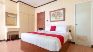 独鲁万RedDoorz @ Downtown Tacloban的卧室配有带红色枕头的大型白色床