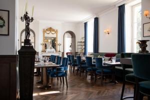 圣埃斯泰夫La Maison d'Estournel的一间配备有桌子和蓝色椅子的用餐室