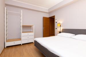 塔林Self-check-in 2 bedroom apartment with a terrace and free parking的卧室配有白色的床和衣柜。