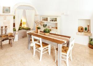 奥斯图尼Alesia luxury suite Ostuni的一间带木桌和椅子的用餐室
