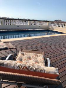 福塔莱萨Angra Praia Hotel的游泳池旁甲板上的长凳