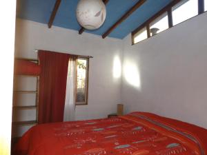HorconCabaña Canto del Viento, 4 personas的一间卧室配有一张带红色毯子的床和窗户。