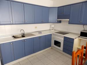 厄尔梅达诺Apartamentos Medano - Mirazul 2的厨房配有蓝色橱柜和水槽