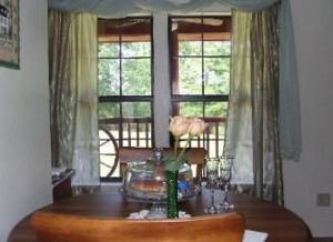 亚历山德里亚Susan's Cottages的一间带桌子和2个窗户的用餐室