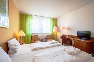 拉贝河畔乌斯季波西米亚泰尔酒店的酒店客房配有两张床和一张书桌