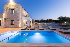 AngelianaDimokritos Villas IV, V, & VI, a homestay experience, By ThinkVilla的一座别墅,在一座建筑前设有一个游泳池