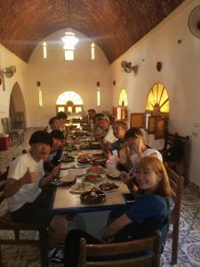 BawatiSafari Camp Bahariya Oasis的一群坐在桌子上吃食物的孩子