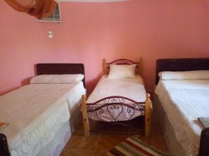 BawatiSafari Camp Bahariya Oasis的配有粉红色墙壁的客房内的两张床
