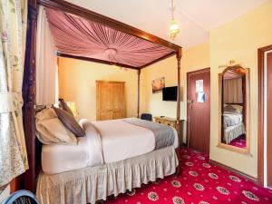 泰恩河畔纽卡斯尔OYO The Royal Hotel的一间卧室配有一张大床和镜子