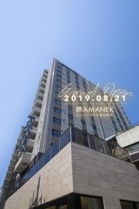 东京HOTEL AMANEK Kamata-Eki Mae的一座高大的建筑,上面有标志