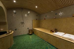 马拉喀什RIAD AZRUR的带淋浴和毛巾浴缸的浴室