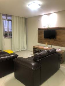 萨尔瓦多Propriedade aconchego de família的客厅配有皮革家具和平面电视