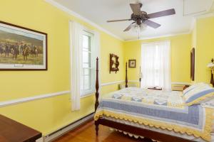 温泉城Anastasia的黄色卧室配有床和吊扇
