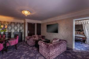 都柏林克朗塔夫城堡酒店的客厅配有粉色家具和电视