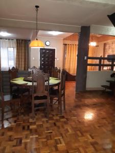 碧瑶Zya 3BR A-House的一间带桌椅和时钟的用餐室