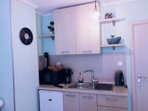 塞萨洛尼基Manina Superior Studios的厨房配有白色橱柜和水槽