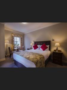 Mountnugent克罗沃高尔夫俱乐部酒店的酒店客房配有一张带红色枕头的大床