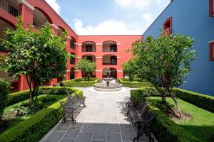 乔卢拉Hotel Real de Naturales的一座庭院,里面设有两个长椅和一个喷泉