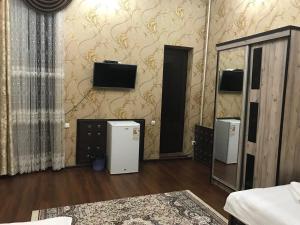 塔什干Real Tashkent的客房设有2台冰箱和1台墙上的电视。