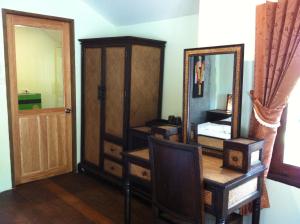 高兰兰达快乐山旅馆的一间设有镜子、梳妆台和门的房间
