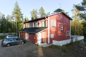 普哈圣山Pyhäkoti Holiday Home的前面有一辆汽车停放的红色房子