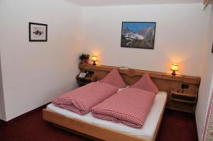 加尔蒂Pension Belvedere的一间卧室配有红色和白色枕头的床