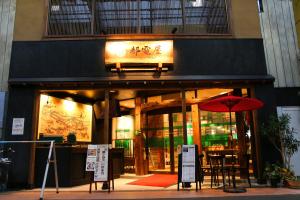 东京都電屋 TodenHotel的前面有红伞的餐厅
