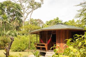 卡维塔Bungalows Aché Cahuita的花园内带吊床的小小屋