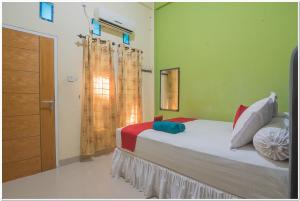 巴厘巴板RedDoorz near Lapangan Tenis Balikpapan的一间卧室设有一张床和一个窗口