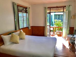 湄南海滩Mali House的卧室设有一张带窗户的白色大床