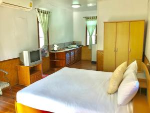 湄南海滩Mali House的卧室配有一张白色大床和电视。