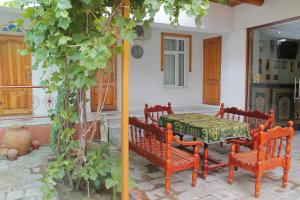 布哈拉布哈拉萨曼尼住宿加早餐旅馆的房屋内带桌子和长凳的庭院