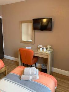 萨顿因阿什菲尔德Central Hotel的一间卧室配有书桌和一张带椅子的床