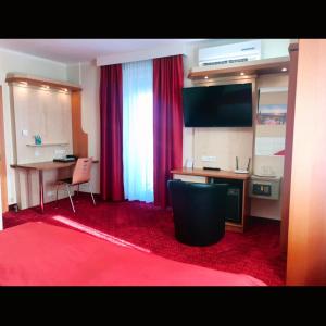克拉根福阿拉基亚酒店的配有书桌和红地毯的客房