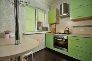 鄂木斯克Omsk Sutki Apartments at Lenina 30的厨房配有石灰绿色橱柜和桌子