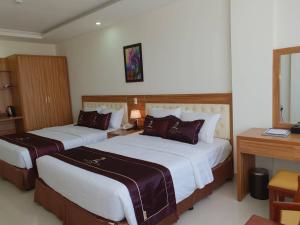 洞海普丛海滩酒店的酒店客房配有两张床和一张书桌