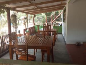 锡吉里亚Pidurangala View Home Stay的一个带木桌和椅子的门廊和游乐场