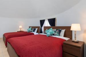 宇流麻Uruma Dome Okinawa的卧室内的两张床,配有红色的床单和蓝色的枕头