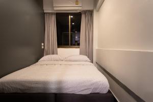 曼谷T2 2 Bedrooms 6 guests Full kitchen 1 min to BTS的一个小房间的一个床位,设有窗户