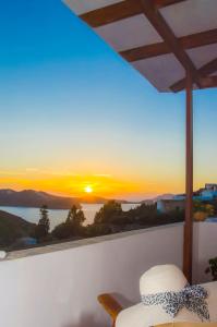 普拉卡米洛斯帕莱欧斯客房酒店的坐在阳台上的帽子,享有日落美景