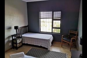 伍斯特Eagle's Crest的一间卧室设有一张床、一个窗口和一把椅子