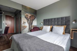 博伦厄品质银河酒店的卧室配有一张大床,墙上挂有大象画