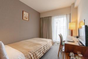 京都金门京都酒店的酒店客房配有一张床和一张书桌及一台电视
