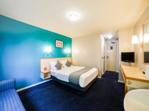 ThrussingtonOYO Sunrise Hotel, A46 N Leicester的配有一张床和一张书桌的酒店客房