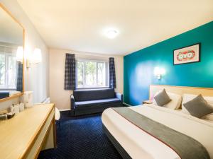 ThrussingtonOYO Sunrise Hotel, A46 N Leicester的配有一张床和一把椅子的酒店客房
