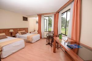 阿里卡Hotel del Valle Azapa的酒店客房设有两张床和窗户。