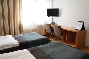 Rokua洛库阿健康Spa度假村的酒店客房设有两张床和一张带电脑的书桌