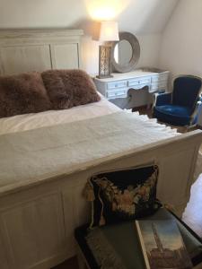 布鲁日Brugge’s House of Friends的一间卧室配有一张床、一把椅子和镜子